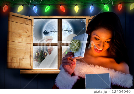 Composite image of sexy santa girl opening gift Composite image of sexy santa girl opening gift 12454040