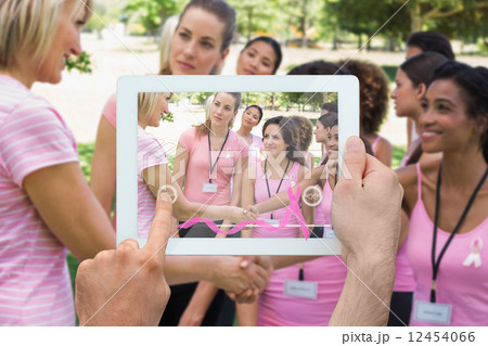 Composite image of hand holding tablet pc 12454066