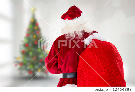 Composite image of santa claus carrying sack 12454898