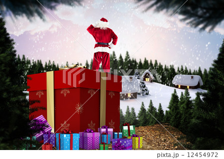 Composite image of santa standing on giant present 12454972