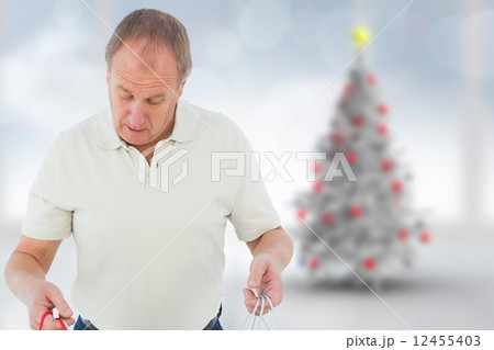 Composite image of man looking in shopping bags Composite image of man looking in shopping bags 12455403