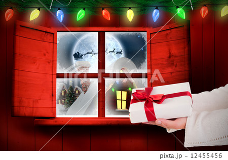 Composite image of woman offering a gift box 12455456