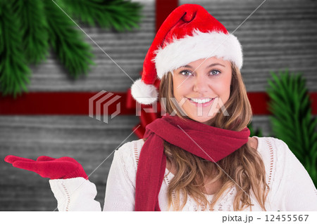 Composite image of festive blonde presenting with hand 12455567