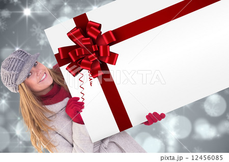 Happy blonde in winter clothes showing card Happy blonde in winter clothes showing card 12456085
