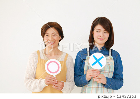 まるばつの札を出す女性達 12457253