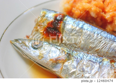 焼いたサンマと醤油をかけた大根おろしの写真素材