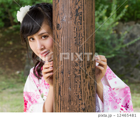 Asian woman in kimono behind wooden pillar Asian woman in kimono behind wooden pillar 12465481