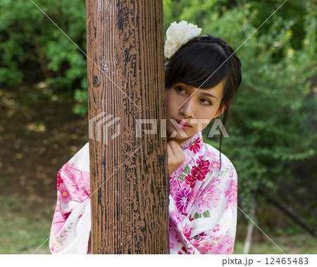 Asian woman in kimono behind wooden pillar Asian woman in kimono behind wooden pillar 12465483