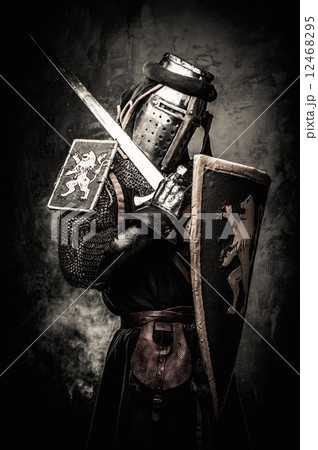 Medieval knight with a sword against stone wall 12468295