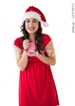 Brunette in santa hat holding gift 12470415