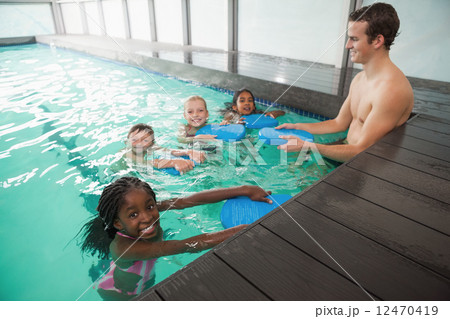 Cute swimming class in pool with coach Cute swimming class in pool with coach 12470419