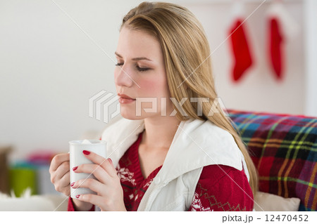 Woman enjoys having a coffee on her couch Woman enjoys having a coffee on her couch 12470452