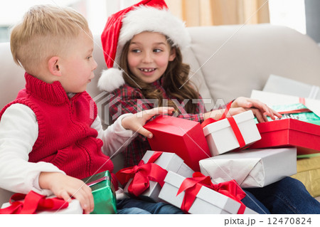 Festive siblings surrounded by gifts Festive siblings surrounded by gifts 12470824