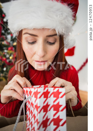 Festive redhead opening christmas gift Festive redhead opening christmas gift 12470953
