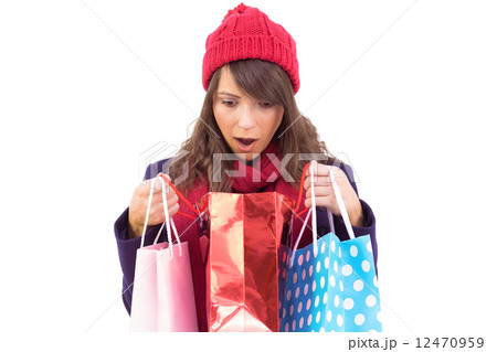 Shocked brunette opening gift bag 12470959
