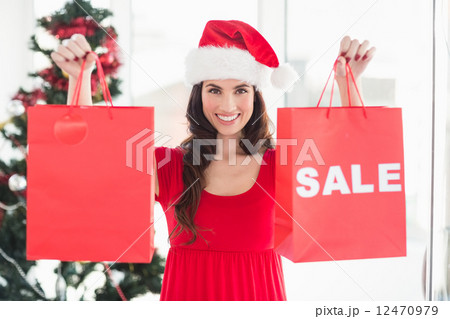 Brunette showing sale bag and shopping bag 12470979