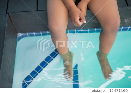 Cute little boy sitting poolside Cute little boy sitting poolside 12471160