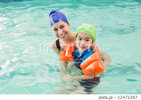 Cute little boy learning to swim with coach 12471267