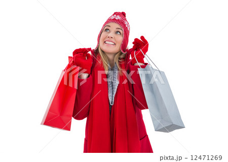 Blonde in winter clothes holding shopping bags 12471269