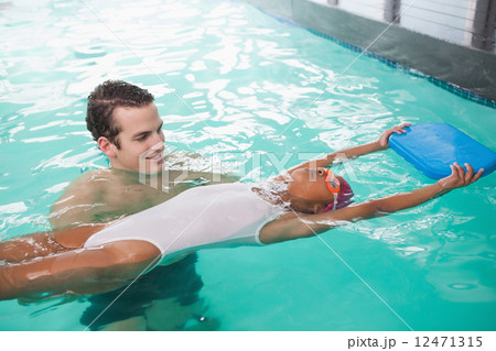 Cute little girl learning to swim with coach Cute little girl learning to swim with coach 12471315