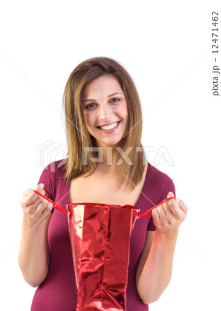 Festive brunette opening a gift bag 12471462