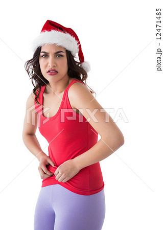 Festive fit brunette pinching her stomach 12471485