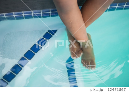 Cute little boy sitting poolside 12471867