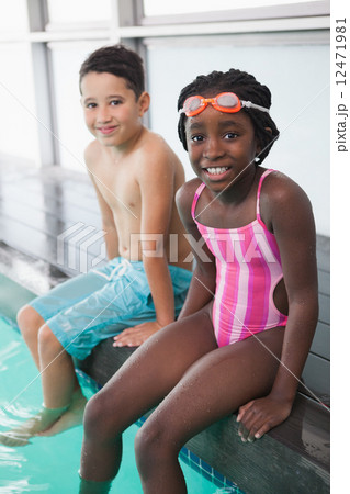 Cute little kids sitting poolside 12471981