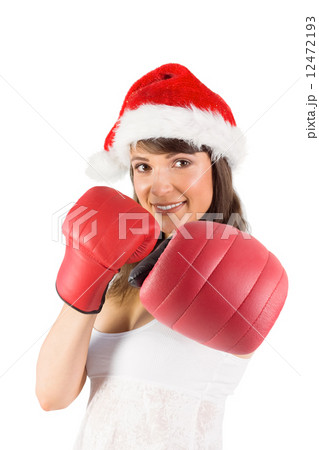 Festive brunette punching with boxing gloves 12472193