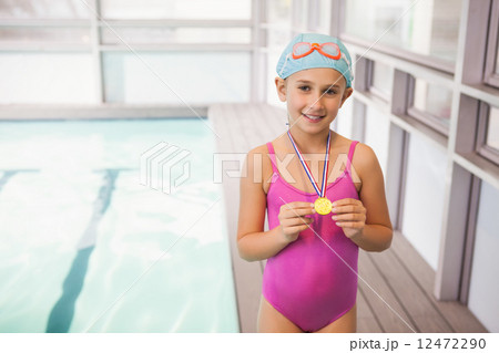 Cute little girl showing her swimming medal Cute little girl showing her swimming medal 12472290