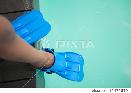 Little boy wearing flippers by the pool 12472650
