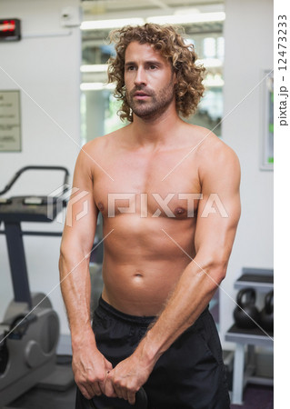 Shirtless man exercising with kettle bell Shirtless man exercising with kettle bell 12473233