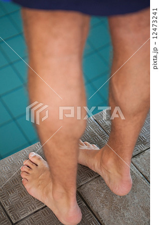 Close up low section of swimmer standing by pool 12473241