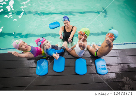 Cute swimming class and coach smiling 12473371