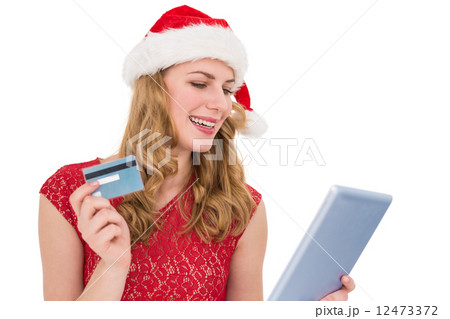 Festive blonde woman using her credit card and tablet pc 12473372