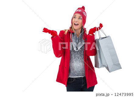 Happy blonde in winter clothes holding shopping bags Happy blonde in winter clothes holding shopping bags 12473995