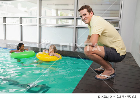 Swimming coach smiling at camera by the pool 12474033