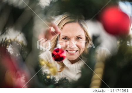 Festive blonde hanging bauble on christmas tree Festive blonde hanging bauble on christmas tree 12474591