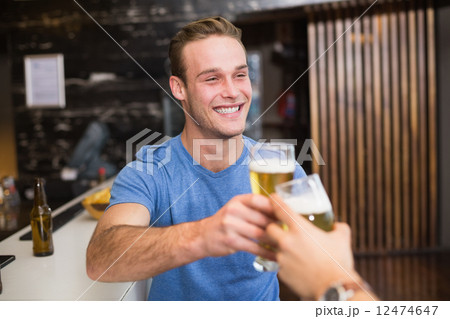 Young man toasting with pint of beer 12474647