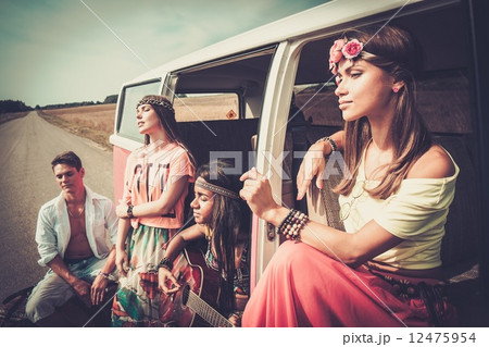 Multi-ethnic hippie friends with guitar on a road trip Multi-ethnic hippie friends with guitar on a road trip 12475954