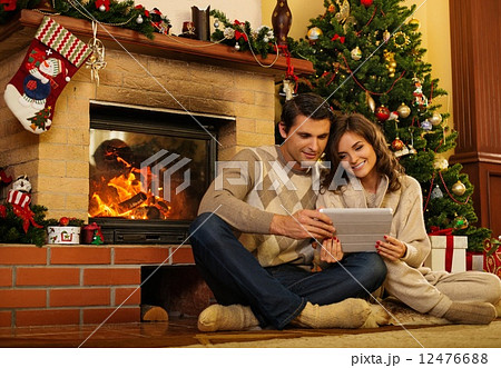 Couple near fireplace in Christmas decorated house interior 12476688
