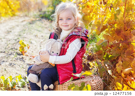 Little girl in warm clothes with toy rabbit 12477156