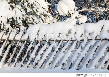The wooden fence filled up by a snow in a countryside. The wooden fence filled up by a snow in a countryside. 12484797