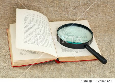 Still life of magnifying glass and old book 12487321