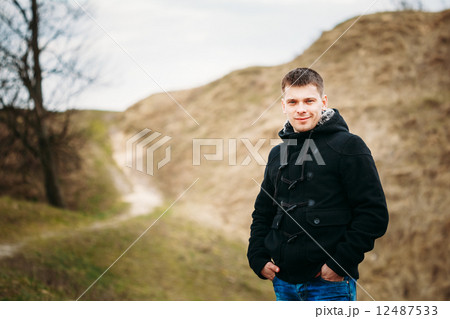 Young Handsome Man Stayed In Field, Meadow In Autumn Day 12487533