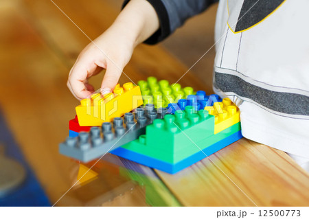 Hand child playing with construction blocks Hand child playing with construction blocks 12500773