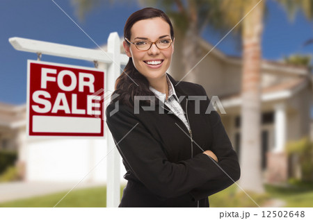 Young Woman in Front of House and Sale Sign 12502648