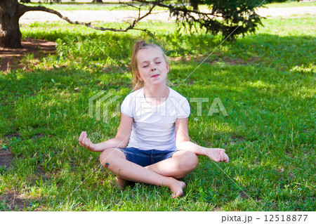Cute girl in lotus pose with sore knee Cute girl in lotus pose with sore knee 12518877