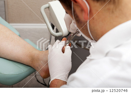 Chiropodist cutting nails 12520746