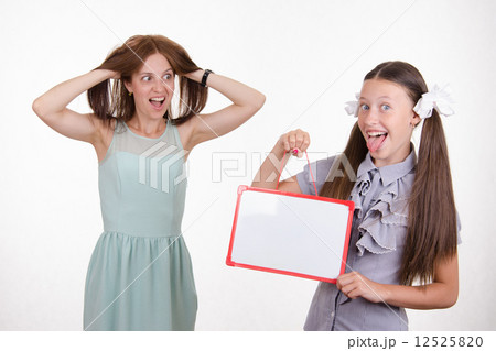 Teacher in horror looking at the student with a sign 12525820
